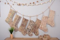 an assortment of old rugs hanging on a clothes line next to a potted plant