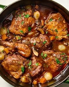 a pot filled with meat and vegetables on top of a table