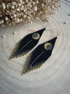 These long earrings made of black beads with fringe and a golden moon motif represent a unique combination of style and mysterious allure. The black color adds elegance to the piece, while the golden moon creates a mysterious and noble accent. Made from Czech beads. Length 4.8 inches(12cm). Width 1.2 inches(3cm). Hypoallergenic clasp. If you want these earrings in a different color, write to me and I will be happy to make them for you. Bohemian Black Tassel Earrings With Round Beads, Black Bohemian Tassel Earrings With Round Beads, Handmade Black Moon Earrings, Handmade Black Moon-shaped Earrings, Black Tassel Earrings With Dangling Beads As Gift, Handmade Black Crescent Earrings, Black Beaded Tassel Earrings With Round Beads, Adjustable Black Crescent Earrings, Black Tassel Earrings With Black Beads For Gift