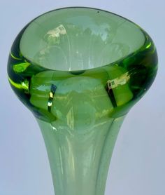 a green glass vase sitting on top of a table