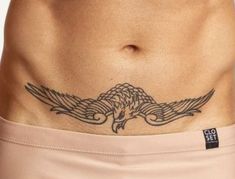 a close up of a person's stomach with an eagle tattoo on the side