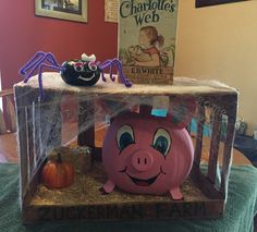 a piggy bank sitting on top of a table next to a sign that says charlotte's web