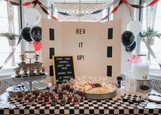 a table topped with lots of desserts and balloons