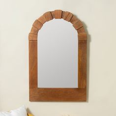 a mirror hanging on the wall above a bed