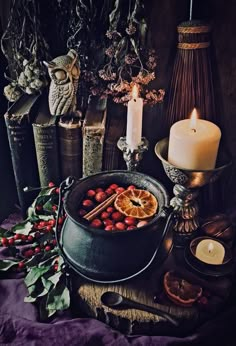 a table topped with candles and fruit on top of it