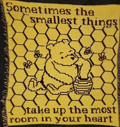 a knitted square with an image of winnie the pooh holding a honey pot