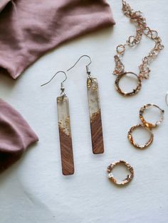 three pieces of jewelry are laid out on a white surface with pink shirt and accessories