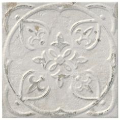 an old white tile with decorative designs on it's face and backround