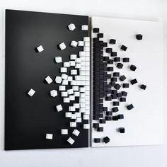 two black and white pieces of art hanging on the wall next to each other with cubes in them