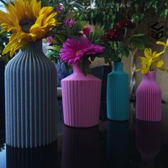 three vases with flowers in them sitting on a table