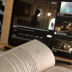 an open book sitting on top of a table next to a laptop computer and tablet