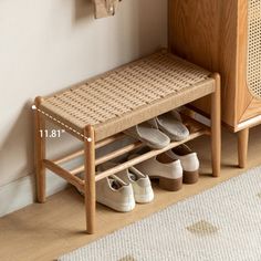 a wooden bench with shoes on it next to a white rug and wall mounted coat rack