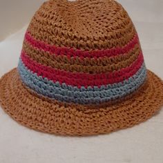 a crocheted hat with red, blue and brown stripes on the brim