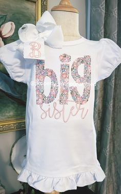 This is the perfect personalized shirt for your newly Big Sister! It comes on a high quality, white, cotton ruffle short or long sleeve shirt. Bow is sold separately. Please choose your fabric and thread color. It can be entered in the personalization box.  When you are selecting the size of the shirt for your child, please keep in mind that it is 100% cotton, and it will shrink a little. The applique is backed with a soft backing to provide protection for sensitive skin from the stitches. Care Big Sister Applique Shirt, Bates Sisters Boutique Shirts, Customizable Cute White T-shirt, Customizable Cute Cotton Tops, White Personalized Crew Neck Shirt, Personalized White Crew Neck Shirt, Cute Personalized White Tops, White Short Sleeve Birthday Shirt, White Fitted T-shirt For Birthday