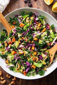 a white bowl filled with lettuce, carrots and other vegetables