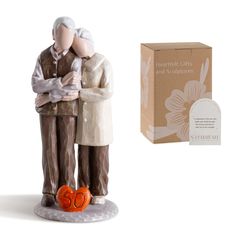 a figurine of two people holding each other with a box in the background