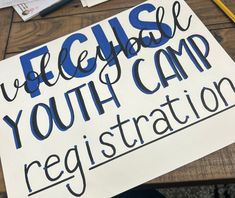 a sign that says please youth camp registration on the side of a table with other items