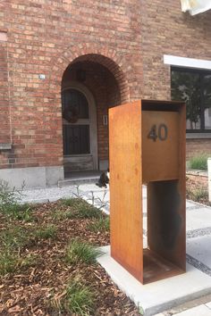 a mailbox sitting in front of a brick building with a number forty on it