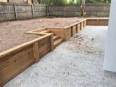 an empty backyard with wooden steps and gravel