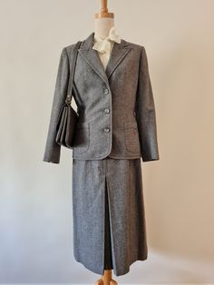 Suitmaster Sydney Australia. Fabulous 1980's Suitmaster Mid Grey Wool Flannel 2 piece suit.  Comprising a fully lined tailored Jacket and fully lined Mid calf length A-line skirt this has beautiful simple cornelli ribbon detailing and is in the most fabulous Condition.  The Jacket:  Fitted and finishing just in the high hip this has seam detailing and a lovely deep notched collar and lapel.  With 3 buttons and patch pockets (both nicely detailed with the matching cornelli work), this has prep sc Classic Wool Skirt Suit For Work, Classic Tailored Wool Skirt Suit, Wool Skirt Suit For Formal Fall Events, Wool Skirt Suit For Formal Fall Occasions, Classic Winter Semi-formal Skirt Suit, Winter Formal Single-breasted Skirt Suit, Classic Winter Skirt Suit For Semi-formal Occasions, Classic Fitted Wool Skirt Suit, Tailored Wool Skirt Suit