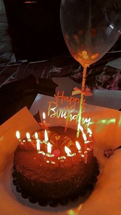 a birthday cake with lit candles on it and the words happy birthday written on top