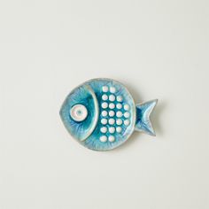 a blue ceramic fish with white dots on it