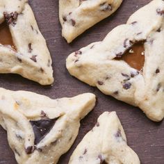 four pieces of chocolate chip cookies on a wooden table with one cut in the shape of a star