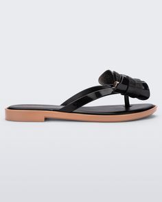 Side view of a Melissa slim strap flip flop in black with bow applique Trendy Beach Sandals With Bow, Summer Beach Flip Flops With Bow, Trendy Synthetic Sandals With Bow, Elegant Beach Sandals With Bow, Chic Jelly Sandals For Vacation, Chic Party Flip Flops, Elegant Synthetic Jelly Sandals For Beach, Elegant Flat Jelly Sandals For Vacation, Chic Flat Flip Flops For Party