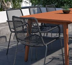 an outdoor table with chairs and a potted plant