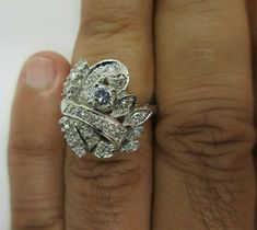 a woman's hand with a diamond ring on top of her finger and an engagement band in the middle