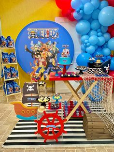 a birthday party with balloons and decorations on the wall, including a pirate ship table