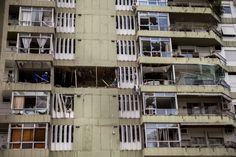 an apartment building with multiple balconies and broken down windows in the middle of it