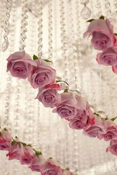 some pink roses hanging from a chandelier