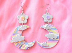 These whimsical polymer clay flower power and moon dangle earrings feature a flower adorned with holographic silver glitter and a pastel tie-dye center. The crescent moon boasts a pastel tie-dye design, with glittery clouds adding a dreamy touch. They are sealed with polyurethane gloss Perfect for everyday kawaii, pastel, and/or hippie looks! They measure approx 3 inches long, attached to either stainless steel wire or clip-ons Please message me if you have any questions or concerns. PLEASE NOTE Glittery Clouds, Fairy Kei Accessories, Kei Jewelry, Pastel Jewelry, Dye Flowers, Yume Kawaii, Flower Moon, Moon Clouds, Pastel Tie Dye