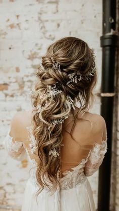 the back of a woman's head with long hair and flowers in her hair