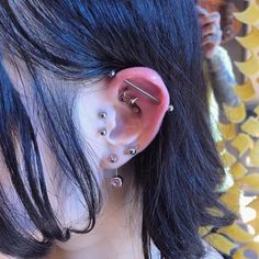 a close up of a person with ear piercings on their ears and behind the ear