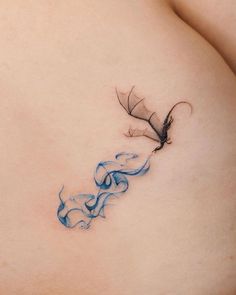 a woman's stomach with a tattoo design on the side of her breast and a bird flying over it