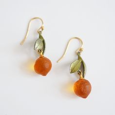 A pair of adorable oranges for your ears! French ear wires Bronze painted leaves Orange glass Earrings drop 1.5 inches Handmade in the USA Goldmakers Jewelry Mission Statement Goldmakers Jewelry creates and curates a comprehensive selection of artfully designed hand-crafted jewelry. We aspire to offer the jewelry enthusiast access to affordable classics as well as fresh innovative designs. Silver Seasons Mission Statement Silver Seasons Jewelry collection is brought to you by designer Michael Mi Amber Czech Glass Drop Earrings, Artisan Gold Earrings With Czech Glass, Amber Brass Earrings For Gift, Amber Czech Glass Earrings With Ear Wire, Nickel-free Amber Czech Glass Jewelry, Amber Czech Glass Nickel-free Jewelry, Amber Colored Nickel Free Czech Glass Jewelry, Amber Nickel-free Czech Glass Jewelry, Nickel-free Recycled Glass Drop Earrings