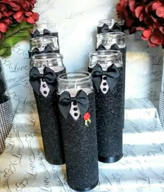 four black glittered glass vases with bows and tuxedo on the side