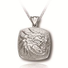 This cushion Cremation Jewelry portrays the mythical dragon; a representation of wisdom and longevity. This outstanding sterling silver cremation pendant comes with an 18", 20" or 24" Italian Sterling Silver Heavy Franco style Chain measuring 2mm thick, a very attractive Jewelry Display box and a Sterling Silver Scoop to assist in filling your Cremation Jewelry. Dimensions are approximately 0.71"H x 0.71"W x 0.24"D Silver Carved Rectangular Jewelry, Carved Silver Rectangular Jewelry, Silver Rectangular Carved Jewelry, Carved Rectangular Silver Jewelry, Traditional Silver Jewelry With Dragon Design, Silver Dragon Design Jewelry For Formal Occasions, Silver Jewelry With Dragon Design For Formal Occasions, Formal Silver Jewelry With Dragon Design, Carved White Gold Necklaces As Gift