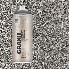 a can of spray paint sitting on top of a black and white speckled wall