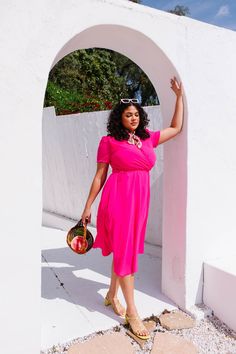 Base color is hot pink. Faux wrap bodice with v neckline. Short fitted sleeve. Ankle length skirt with a removable waist tie. Hidden back zipper. Lined throughout bodice and skirt. Fabric has no stretch. Nursing friendly. Fabric is 100% Polyester. Gentle wash cold; lay flat or hang to dry. Low iron if needed. Available in sizes XXS, XS, S, M, L, XL, 1X, 2X, 3X, 4X, + 5X! summer dress, plus size fashion, summer outfit, matching mom and kid outfit, summer style inspiration, pink dress, midi dress Knee-length Wrap Dress For Day Out, Trendy Pink V-neck Midi Dress, Pink Solid Color Midi Dress For Party, Pink Solid Color Party Midi Dress, Pink Party Midi Dress, Pink Solid Color Summer Dress, Spring Knee-length Short Sleeve Dress In Solid Color, Feminine Pink Dress With Surplice Neckline, Pink Knee-length Solid Color Dress