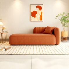 an orange couch sitting on top of a white rug in a living room next to a lamp