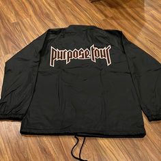 a black jacket with the word poppop written on it sitting on a wooden floor