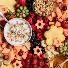 an assortment of fruits, nuts and yogurt are arranged on a platter