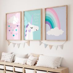 three unicorn pictures hang on the wall above a bench with storage bins underneath them