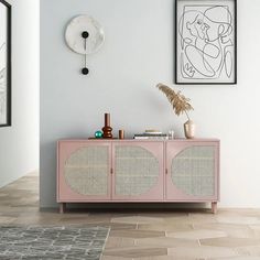 a living room with a pink cabinet and pictures on the wall