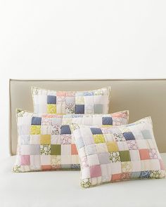 two pillows sitting on top of a bed next to each other in front of a white wall