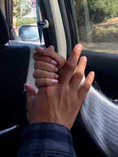 a person holding their hands in the back seat of a car