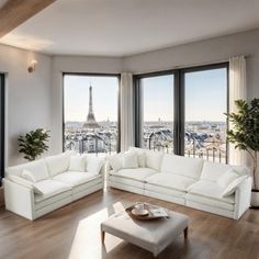 a living room filled with white furniture and large windows overlooking the eiffel tower